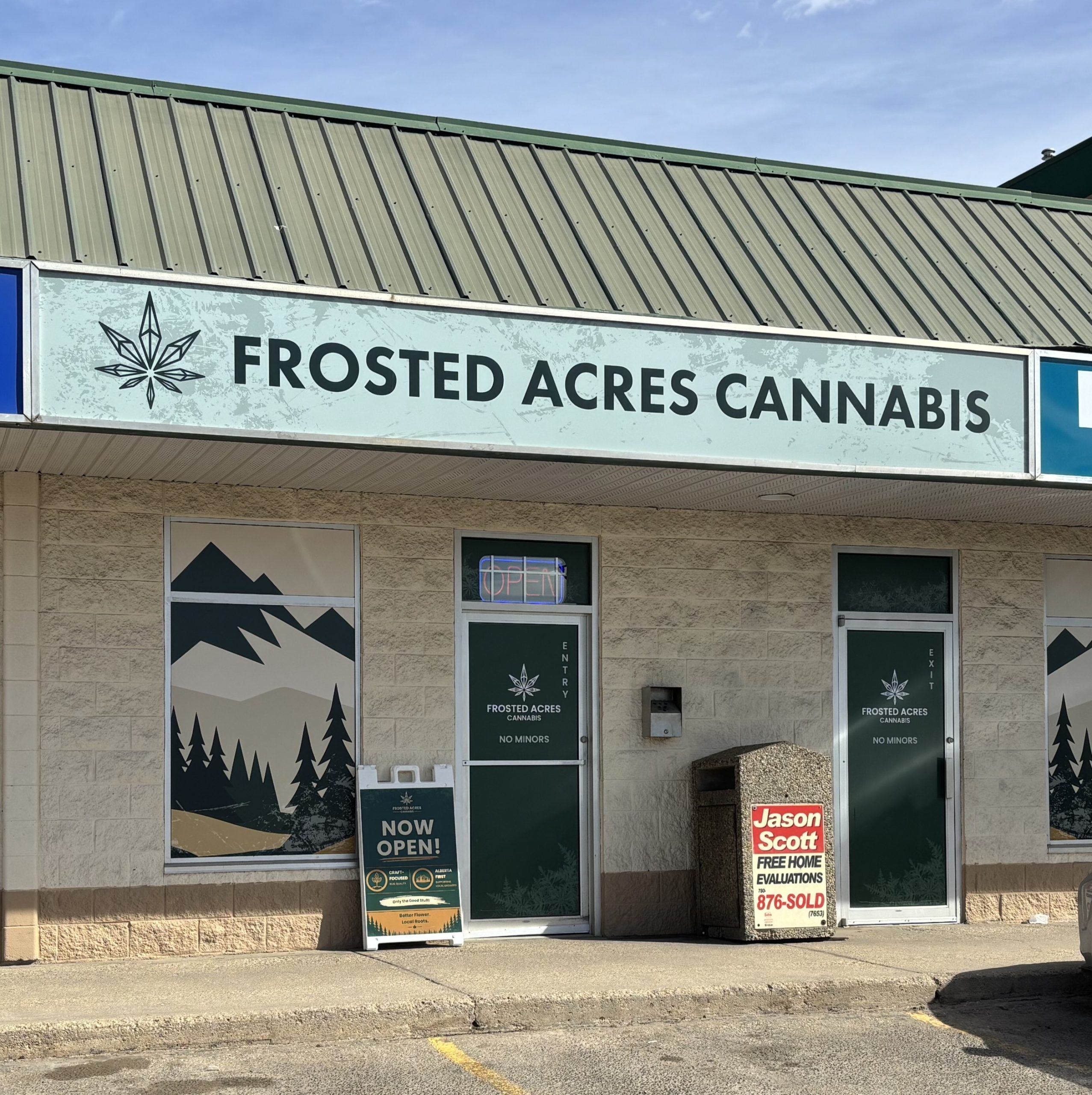Exterior storefront of Frosted Acres Cannabis dispensary with mountain decals.